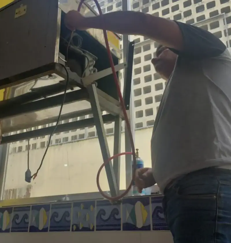 Técnico Rodrigues MK realizando manutenção em equipamento de refrigeração