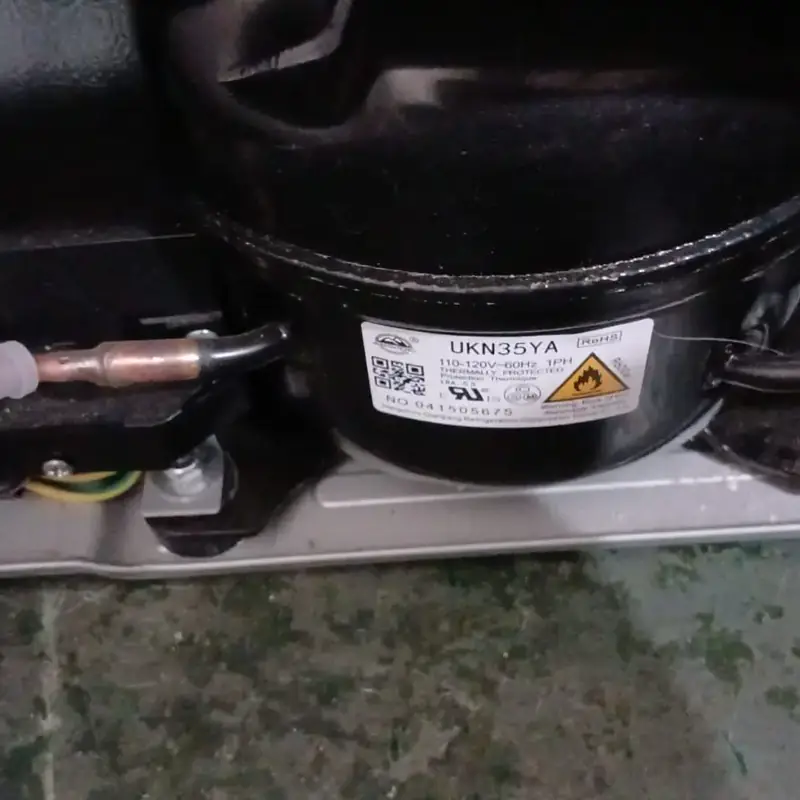 Compressor instalado em geladeira durante manutenção técnica